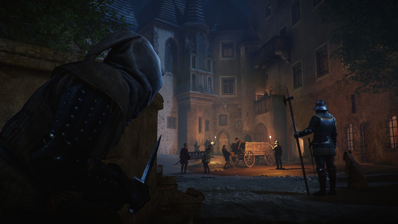 A hooded figure watching guards in a torch-lit town square at night in Kingdom Come: Deliverance II